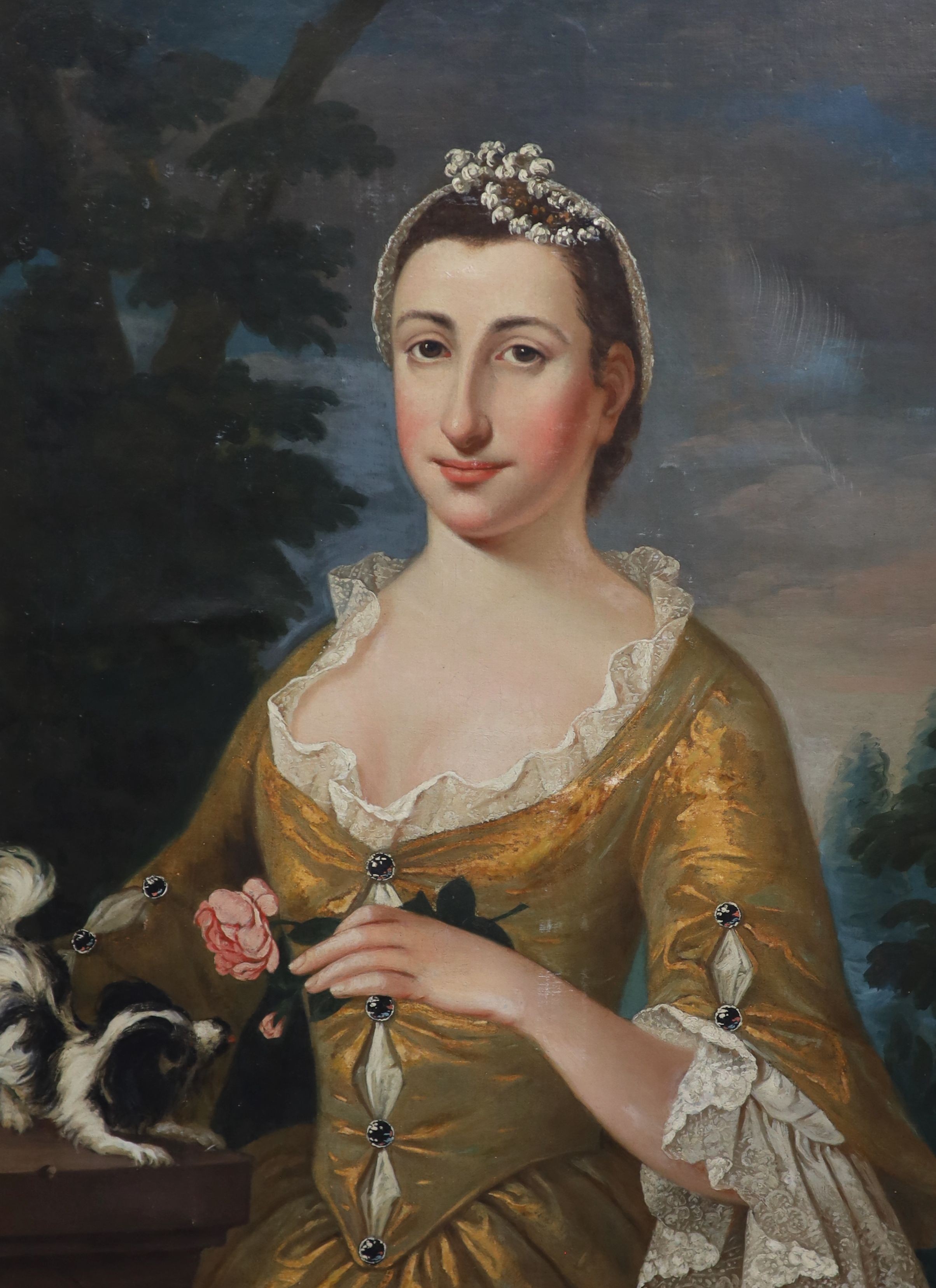 Early 18th century French School, Portrait of a lady wearing a yellow dress holding a rose with a lap dog beside her, oil on canvas, 82 x 62cm